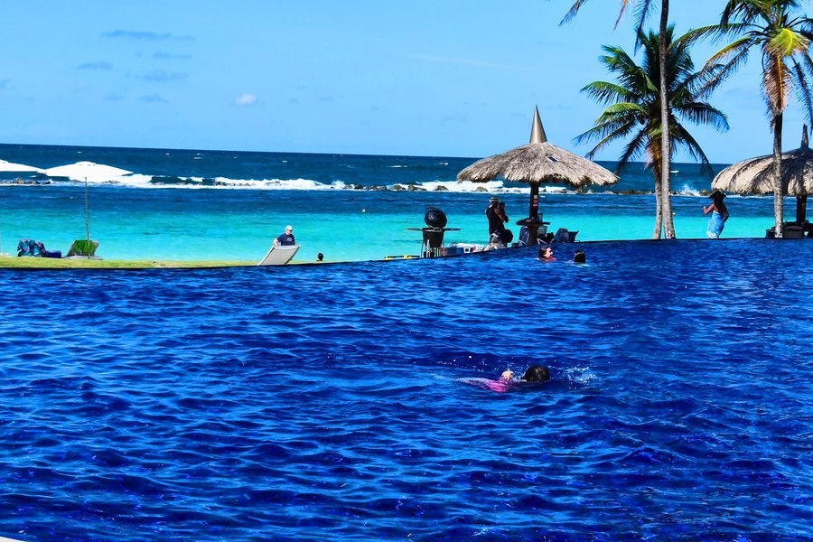Piscina de praia privativa com coqueiros, do folder do Caribe VIP
